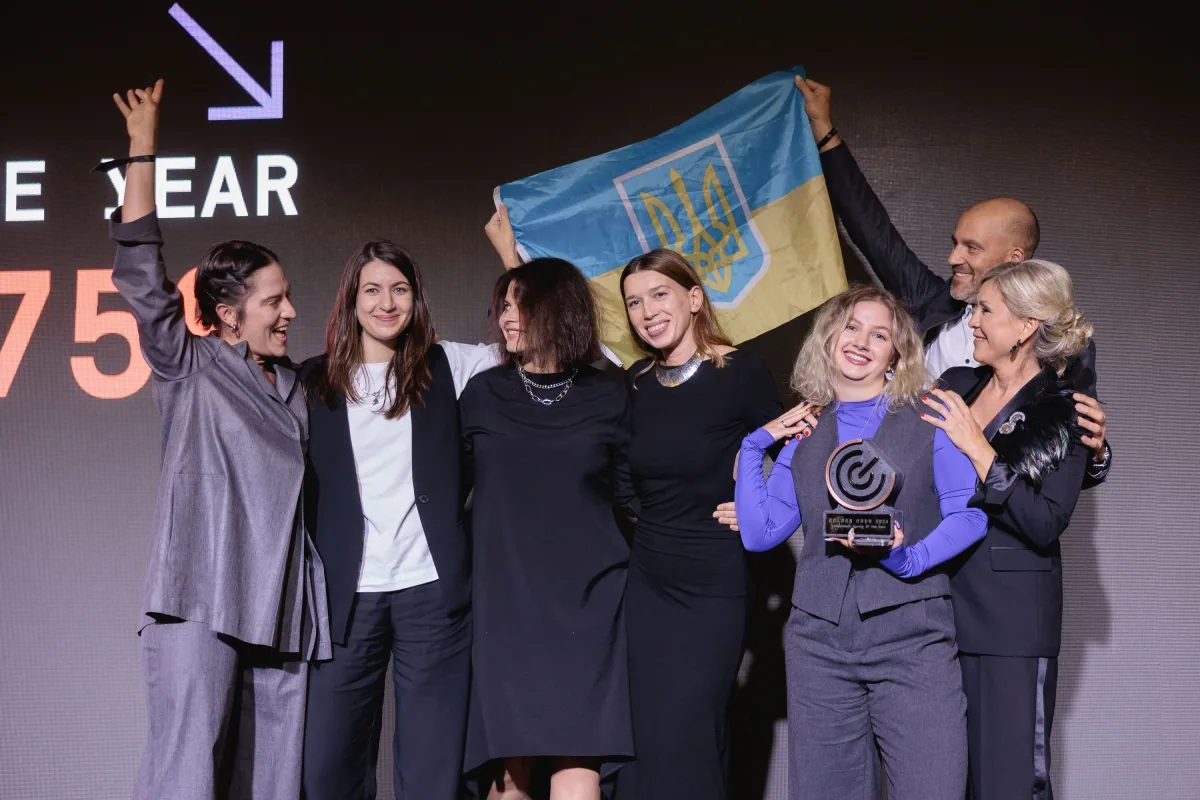 The team celebrating on stage with a Ukrainian flag