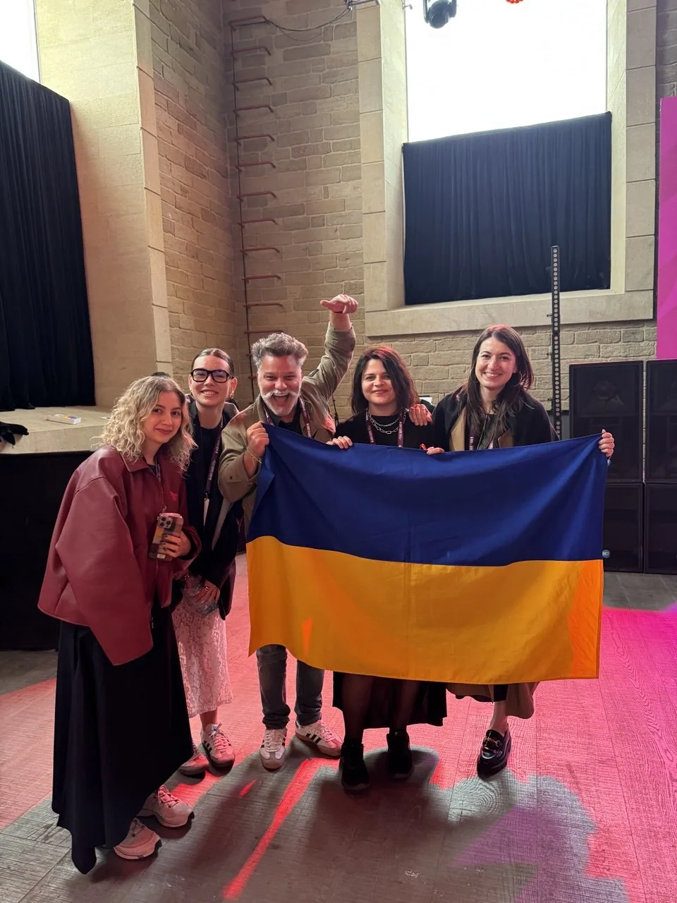 The team with a Ukrainian flag and award trophies